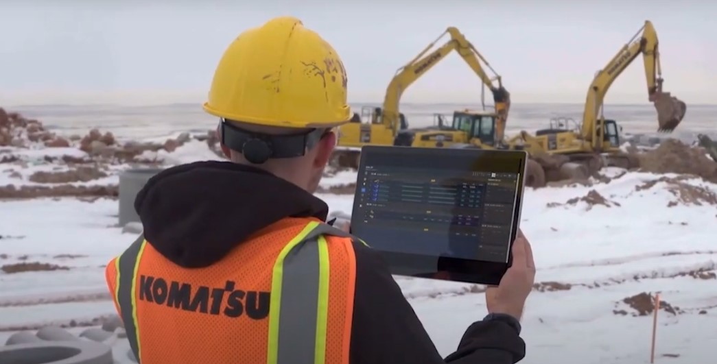 A worker uses a tablet at a job site.