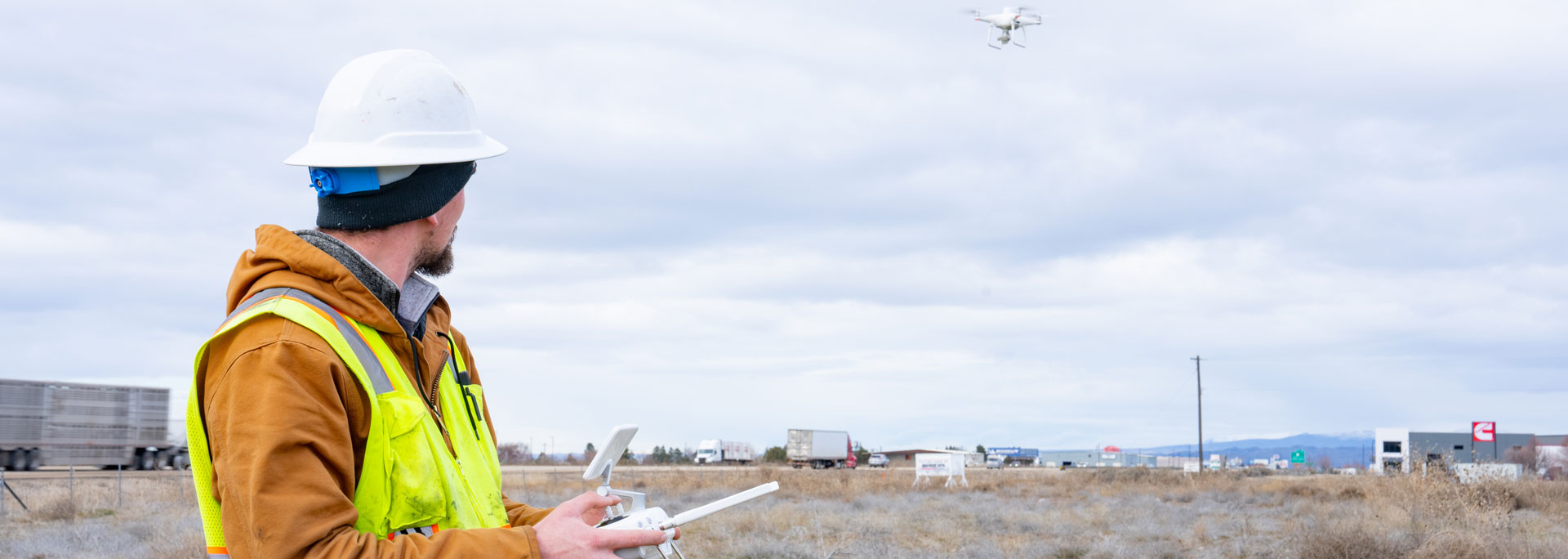 A drone operator flying a drone over a job site.